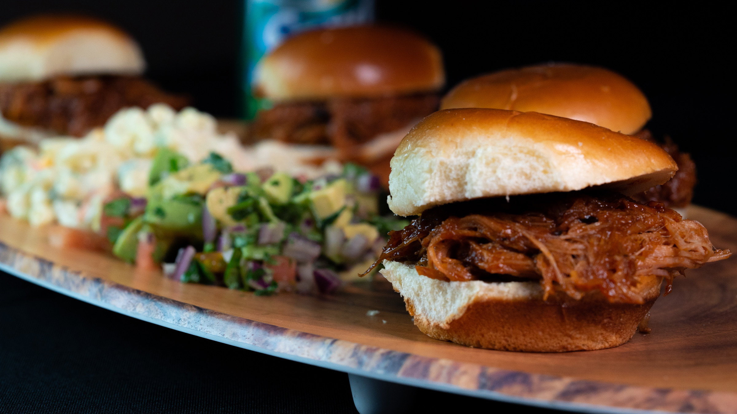 Brisket sandwich with avocado salad on wood board