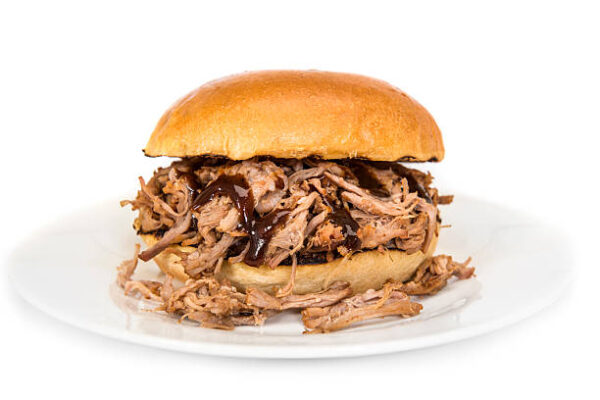 Pulled pork sandwich topped with BBQ sauce on a white plate against a white background; "Normal West Post Prom" label visible.